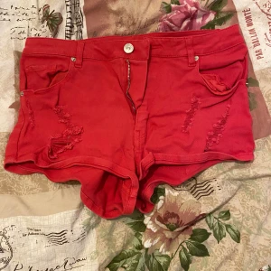 Röda korta shorts  - Röda korta shorts med slitningar i fram, finns i fler färger 