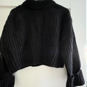 Stickad croppad tröja - Svart stickad croppad tröja med uppvikta ärmar från Gina tricot 