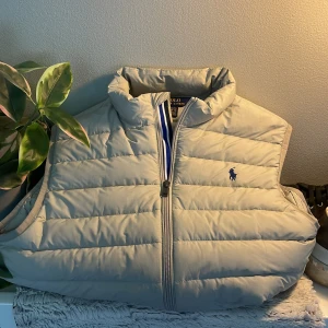 Vit/beige polo Ralph Lauren väst - Riktigt snygg Vit polo Ralph Lauren väst i storlek S men passar M. Helt ny inga fläckar eller hål. Slutsåld på nätet. Perfekt nu till Hösten och Vintern🍁❄️Nypris 3195kr. Pris går alltid att diskuteras. 