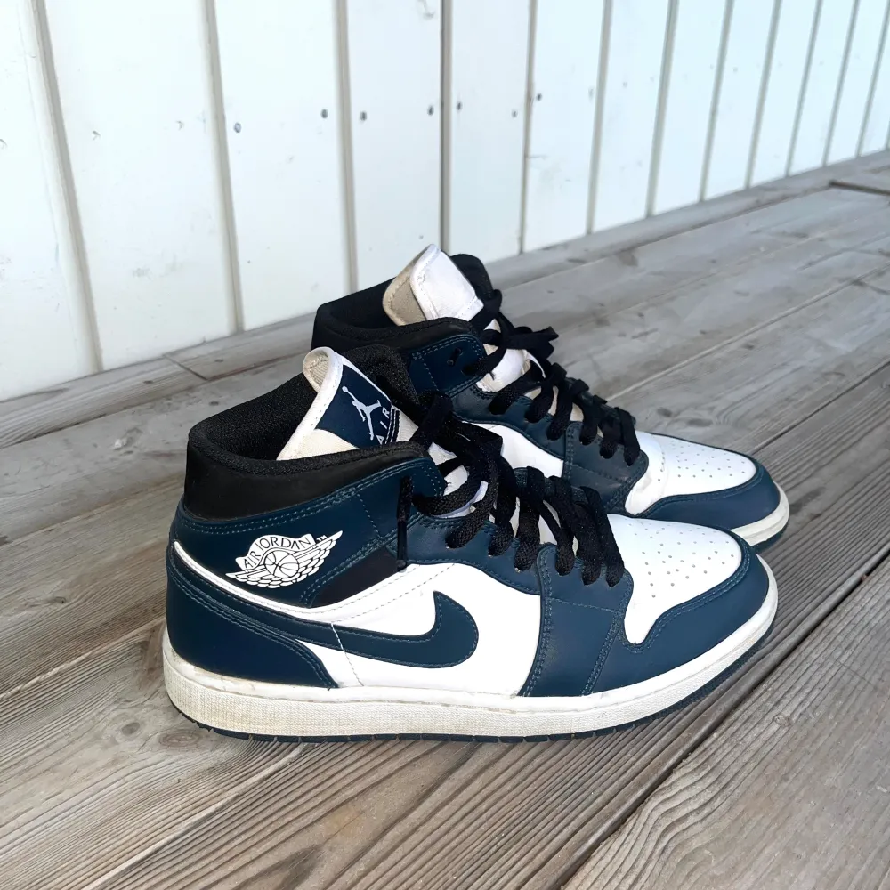 Säljer ett par Nike Air Jordan 1 Mid i blått och vitt. Skorna är i gott skick och har inte använts mycket. US 9 EUR 42.5 UK 8. Skor.