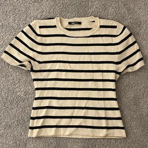 Randig stickad topp - Randig stickad/ribbad topp från Ginatricot som är oanvänd i storlek L
