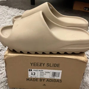 Yeezy slide - Säljer dess Yeezy slides i färgen dessert sand. Är lätt använda och inte mycket synligt slitage och kommer såklart tvättas innan de fraktas.