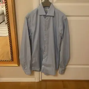 Väldigt fin ljusblå skjorta från John Henric som enbart är provad en gång 