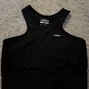 Stronger Crop Top - Säljer min svarta crop top i storlek S från stronger i modellen Etna 2.0. Färgen på insidan där storleken och tvättråd står har skavts av lite. Skick: 9/10. Prislapp och påsen till crop toppen medföljer.