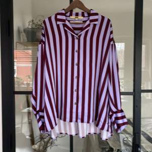 Skjorta lila/vinröd randig från Gina Tricot. Storlek M Kvalitet: 100% polyester 