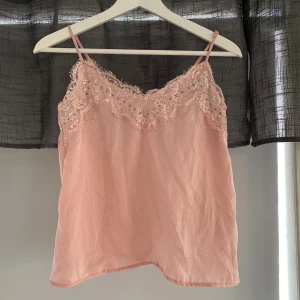 Spetslinne  - Rosa spetslinne med ”nitar” och ställbara axelband.  Möts endast upp ( vanligtvis i city).