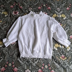 Spetsblus med volang - Färgen är vit, köptes från Monki, i jättebra skick. Passar XXS, XS och S. Den är tillräckligt stretchig.