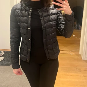 Svart tunn dunjacka  - Tunn svart dunjacka i storlek XS. Funkar även för XXS. 