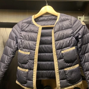 Säljer en moncler jacka i mörk blå  - Säljer min mörkblåa moncler jacka med vit kant och fyra små fickor där framme i storlek 8 år