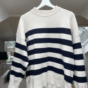 Randig stickad tröja  - Randig vit och blå stickad tröja med u-ringning. Ifrån Zara i storlek M. 