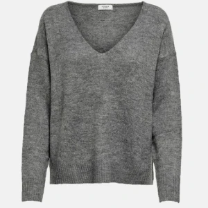 Grå stickad tröja  - jättefin grå v ringad stickad tröja från hm. Använd några gånger, lite nopprig men jätteskön att ha på sig. 