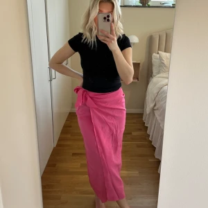 Rosa midikjol  - Omlottkjol som man knyter. Otroligt fin färg. Som ny! 