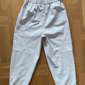 Aby Faux pants - Neo Noir - Märkesbyxor i fakeläder som inte längre går att hitta i butik! Knappt använda, inga defekter. Resår i midjan.  Total längd: 92 cm. Midja: 35 cm när resåren ej är utdragen. Innerbenslängd: 62 cm. Pris är diskuterbart.  Nypris 900 kr! 