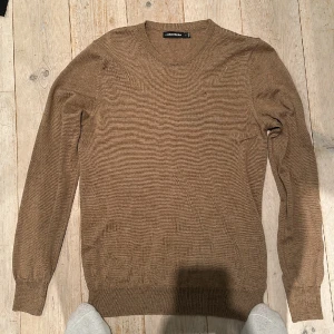 Brun J.Lindeberg tröja - Skick: 9/10 bara använd ett fåtal gngr Material: Ull Storlek: S Killen på bilden är 1.85 m. Vid funderingar är det bara att skriva.