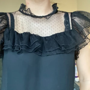 Svart blus - Svart blus med volanger