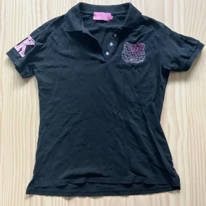 Hello Kitty t-shirt/pikétröja - Några paljetter saknas och det finns en liten fläck på insidan av kragen, men det är inget som märks (se bilderna). Storleken är XL men skulle säga att den är mer onesize då jag har haft den mycket även om min storlek brukar vara XXS