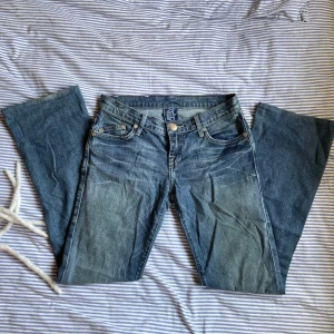 Victoria Beckham jeans - VB jeans med beiga kronor, saknar dock stenar (bild 4) o är lite slitna längst nedtill (bild 5) men annars i bra skick! Har tyvärr inga bilder med jeansen på men de är i lowwaist bootcut modell. Hör av dig vid intresse 🫶🏻🫶🏻