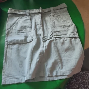 Kjol  - Militärgrön kjol från H&M storlek 38/40 med fickor och skärp. 