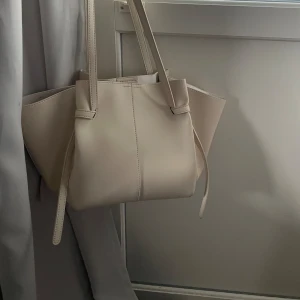 Beige väska - Säljer min fina beiga väska. Funkar så bra till skolan och till vardags.Den är mellanstor. Använd fåtal tillfällen.🌸