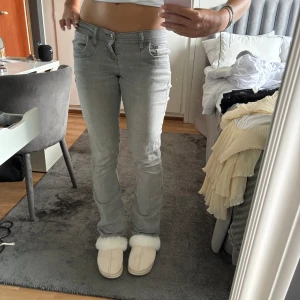 Ljusgrå jeansbyxor - Ett par ljusgrå jeansbyxor i storlek S. Byxorna har en normal passform och är lowwaist. De har en klassisk femficksdesign och är tillverkade i ett stretchigt material för extra komfort.