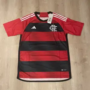 Säljer en replika av Flamengo-tröjan, storlek M. Tröjan är i perfekt skick, aldrig använd och med alla originaltaggar kvar.