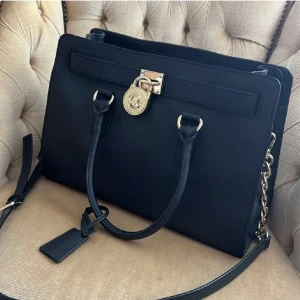 Michael Kors Hamilton  - Michael Kors Hamilton väska. Äkta säklart. Väskan är sparsamt använd och i gott skick. Färg : Svart  Bredd: 35 cm Höjd : 25 cm 