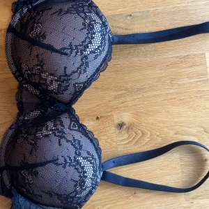 Svart spets-bh - Säljer en snygg svart bh med spetsdetaljer. Den har justerbara axelband och hakknäppning bak. Perfekt för en festlig kväll eller när du vill känna dig extra fin. ny oanvänd🖤🤎