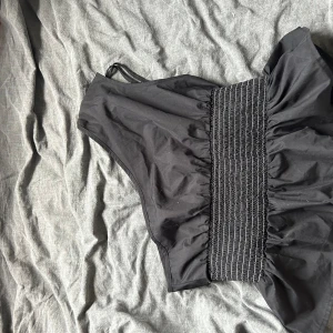 Svart bikiniöverdel - En svart överdel med rynkad detalj framtill. Överdelen har en bred resår för extra stöd och justerbara axelband.