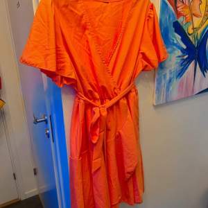 NY Orange klänning stl XL  Med resår i midjan och tillhörande midje band  Härliga fjärilsärmar  