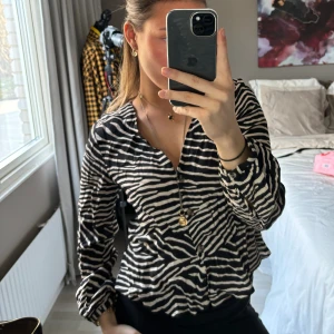 Mönstrad blus - As snygg zebramönstrad blus med najs v ringning. Perfekt till både vardag och fest