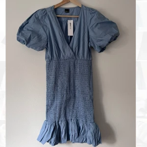 Blå klänning - Klänning med tight över kroppen och puffiga ärmar. 