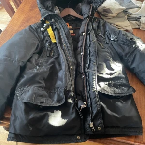 Jacka  - Sprucken i sömmen på två ställen och dragkedjan har skadats se bilder  Går att laga 