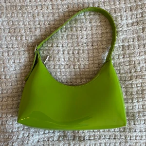 Grön väska - Handväska, köptes i USA. Den har en liten smink fläck inuti från en läppenna, men annars fint skick!