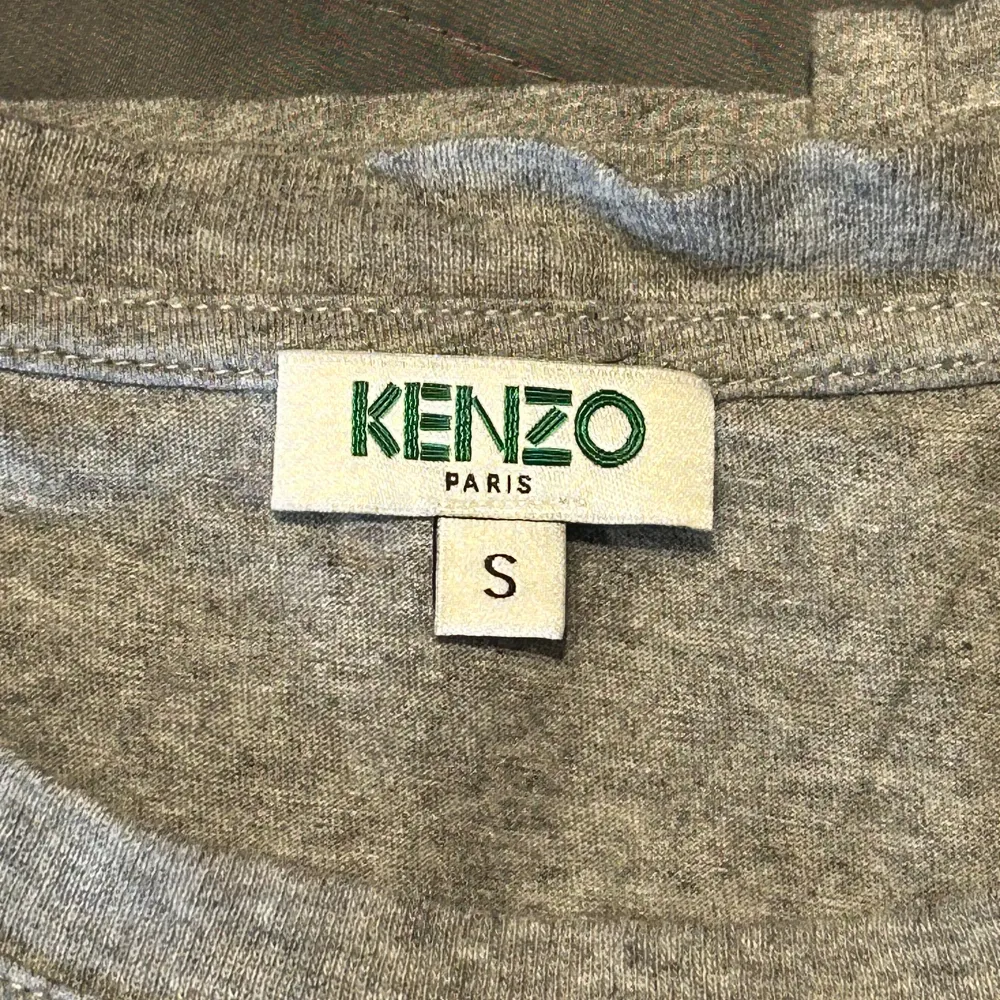 Säljer denna gråa Kenzo tröja som är använd fåtal gånger och är i bra skick. Tröjan är i storlek S och säljer den för 200 kr . T-shirts.