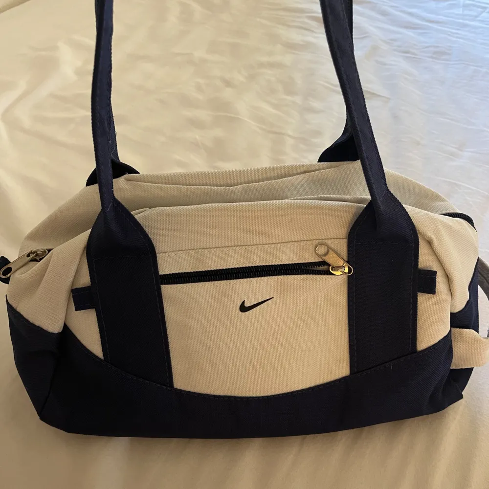 As cool blå/vit liten vintage väska från 90-talet❤️ 4 mindre fickor, en på utsidan❤️små fläckar på framsidan som syns i sista bilden men inga större anmärkningar❤️. Väskor.