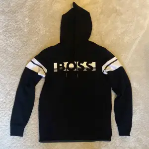 Svart Hugo boss hoodie med vita detaljer. Nästan helt ny, använd 2 gånger. Storlek S.