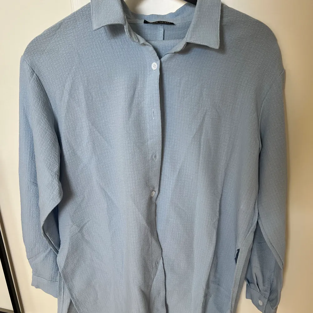Ljusblått somrigt set med matchade skjorta och byxor.   Vita knappar längs med skjortan.   Endast använd 2-3 gånger, säljer pga att den blivit för liten.   Storlek XS med sitter mer som S då den är oversized.   Nypris: 329kr. Skjortor.