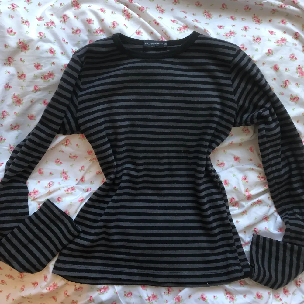 Säljer denna jättesnygga Brandy Melville tröja då jag inte gillar hur den sitter på just mig </3 Skönt och stretchigt material. Använd ett fåtal gånger och har inga synliga tecken på användning💗 Grå/Svart randig.. T-shirts.