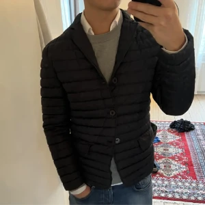 Dondup jacka - (Nypris 2799 mitt pris 1056kr) tvär fet Dondup Jacka! en Blårandig vattentät quiltad dunjacka för herr , öppen krage, fickor, fodrad insida, vadderad med gåsfjädrar, ficka med allmän knappstängning. Använd men i utmärkt skick! 