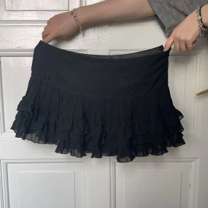 Lågmidjad minikjol  - Svart lågmidjad minikjol med volanger💓 Superfint skick. Storlek M men skulle säga att den är mer som en S! 