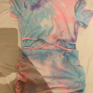 Kläning  - Kläning i i fyra olika färger öppen på magen använd 1 gång 