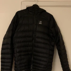Haglöfs jacka - Fin haglöfsjacka i storlek large men passar även mig som har medium i storlek. Den har ett väldigt litet hål på högerarm vid armbågen (se tredje bild) som är nästintill osynlig med blotta ögat men utöver det är den i toppen skick.  Nypris: 3095kr