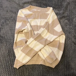 Randig stickad tröja - Här är en skön stickad tröja som är knappt använd, alltså fint skick! Beige och vit randig. Den passar storlek S-M. Priset kan diskuteras💗💗💗