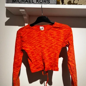 Långärmad kroppad tröja - Tröja i en fin orange färg. Öppen i ryggen. Bra skick. 