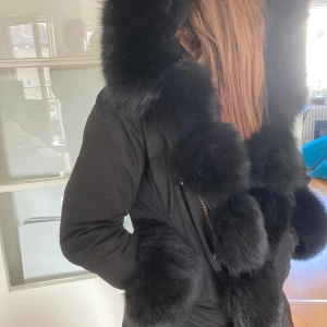 Parka med päls - Svart parka med äkta päls, knappt använd och avtagbar päls på hela jackan. Otroligt varm och gosig på vintern men även fin på våren eller hösten utan pälsen.  Stora fickor och helt fungerande. Hör av er om ni har frågor☺️