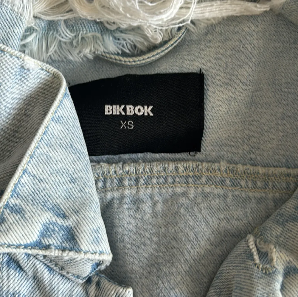 Croppad jeansjacka från BikBok i storlek XS, passar dock S också då den är oversized. Riktigt snyggt jeansmaterial med slitningar på jackan. Använd fåtal gånger så fortfarande i nyskick!💖 Skriv för fler bilder. Jackor.