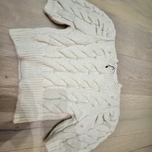 Stickad tröja med pärlor - Vit kabel stickad tröjja med pärlor. Puffärm. Superbra skick. Nypris 400:-