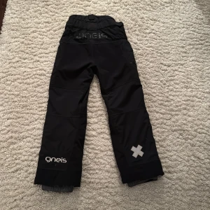 Skidbyxor Gneis stl 152 - Bästa vinterbyxorna! Gneis Gizmo fodrad täckbyxa. Vattentäta och förstärkta med slitstarkt cordura-tyg på knäna och över baken.  Extra resår med kardborre för att reglera midjestorlek. Snölås/dragkedja vid bensluten. Nypris: 1400kr. Mycket fint skick!  
