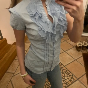 Blå blus - Blå blus med detaljer på bröstkorgen