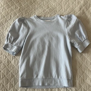 Tröja med puffärm - En ljusblå tröja från Holly and Whyte med (Lindex) puffärm.  Obs! Bekostar ej din frakt 